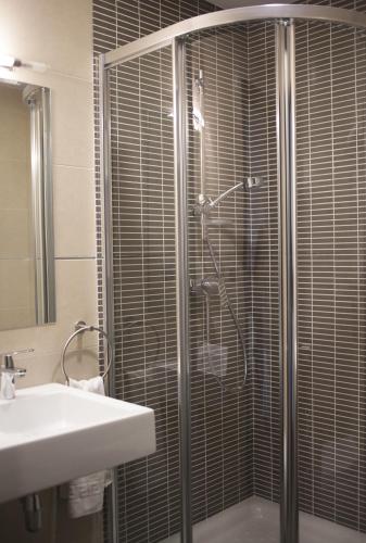 a bathroom with a glass shower with a sink at Hotel Restaurante El Corte in Casabermeja