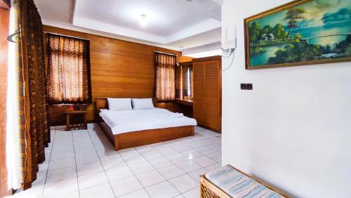 - une chambre avec un lit et une peinture murale dans l'établissement Sukanagalih Resort by Ruang Nyaman, à Cimacan