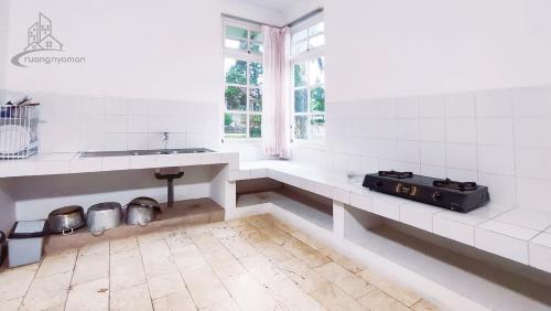 Una cocina blanca con fregadero y ventana. en Sukanagalih Resort by Ruang Nyaman, en Cimacan