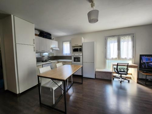 une cuisine avec une table en bois et une salle à manger dans l'établissement Le pied à terre parisien - 77/94, à Pontault-Combault