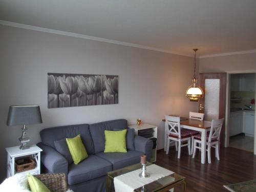 ein Wohnzimmer mit einem blauen Sofa und einem Tisch in der Unterkunft Ferienwohnung "Fördekieker" in Ulstrupfeld