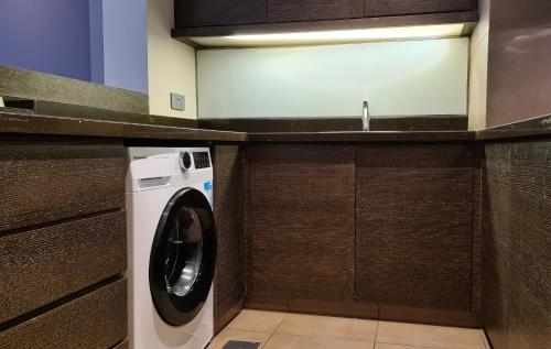 a washer and dryer in a small bathroom at Four Points by Sheraton Al Ain in Al Ain