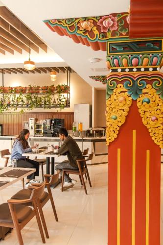 two people sitting at tables in a restaurant at Mila Hotel in Kathmandu