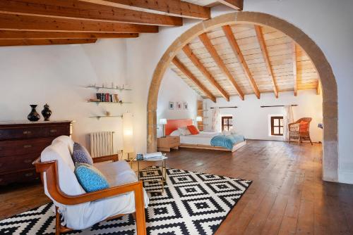 una gran sala de estar con un arco y un dormitorio en Jesus, en Pollensa