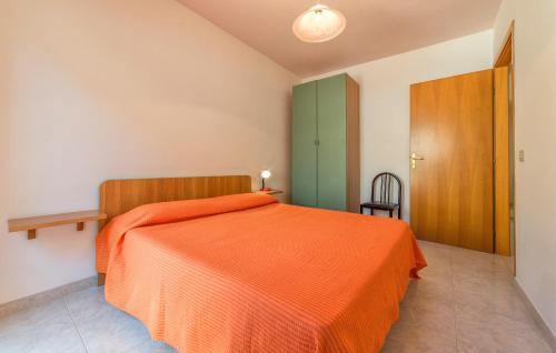 a bedroom with a bed with an orange bedspread at Fronte Mare Capo San Marco in Sciacca