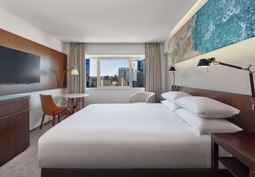 a hotel room with a large bed and a window at Hyatt Regency Brisbane in Brisbane