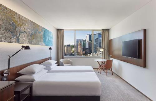een hotelkamer met 2 bedden en een televisie bij Hyatt Regency Brisbane in Brisbane
