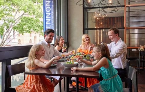 a group of people sitting around a table in a restaurant at Hyatt Regency Brisbane in Brisbane