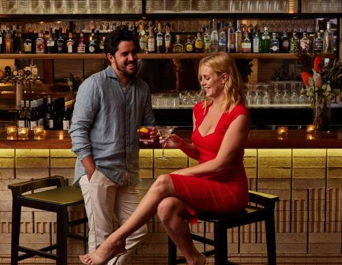 a man and a woman sitting in a bar at Hyatt Regency Brisbane in Brisbane