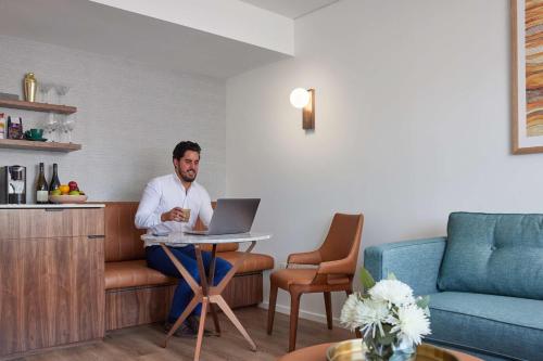 a man sitting at a table with a laptop at Hyatt Regency Brisbane in Brisbane