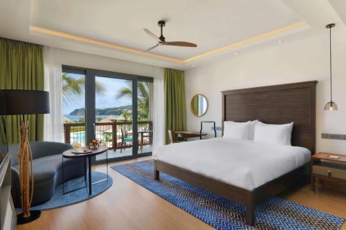 ein Schlafzimmer mit einem Bett und einem Schreibtisch mit einem Stuhl in der Unterkunft InterContinental Dominica Cabrits Resort & Spa, an IHG Hotel in Portsmouth