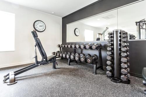 a gym with a row of dumbbells and a mirror at Katrinelund Gästgiveri & Sjökrog in Stora Mellösa