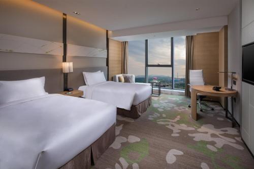 a hotel room with two beds and a television at Holiday Inn Nanjing Harbour by IHG in Nanjing