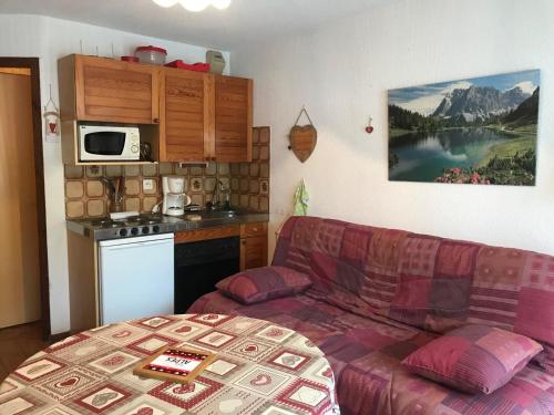 a living room with a couch and a kitchen at Studio Samoëns, 1 pièce, 2 personnes - FR-1-629-77 in Samoëns