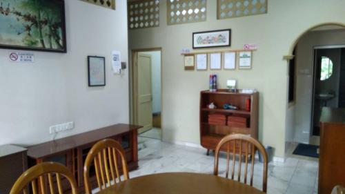 a dining room with a table and chairs and a cabinet at Vynn's @ Banda Kaba in Melaka