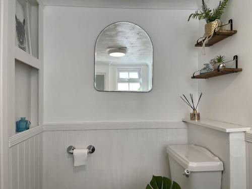 a white bathroom with a mirror and a toilet at The Deal Retreat in Kent
