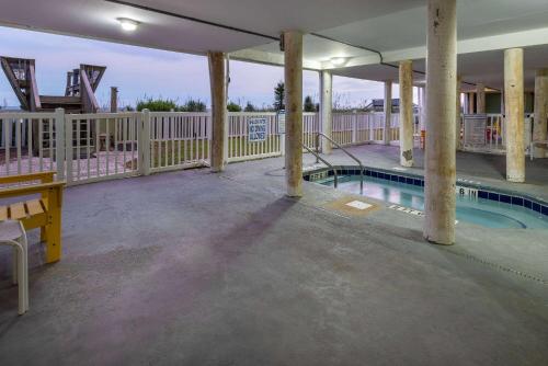 a swimming pool in a building with a fence at Sandpebble Beach Club Surfside Beach a Ramada by Wyndham in Myrtle Beach