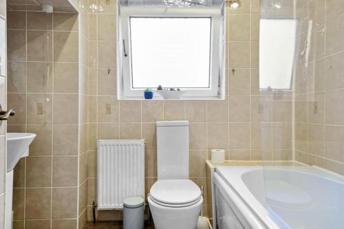 a bathroom with a toilet and a tub and a window at Spacious 3 bedrooms house in Bolton Upon Dearne Up to 6 Guests! 