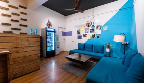 sala de estar con sofá azul y mesa en Locomo Mumbai - Stay Work Eat en Bombay