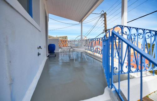 a balcony with a blue railing and a table at Fully renovated 2 bedroom apartment near the restaurants and shops in Ioulida, Kea in Ioulis