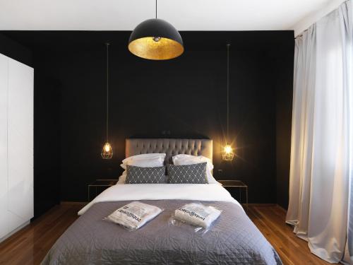 sypialnia z dużym łóżkiem z czarną ścianą w obiekcie Athenian Apartment in the center with Jacuzzi w Atenach