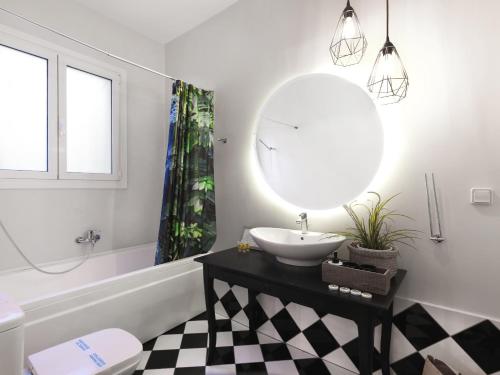 W łazience znajduje się umywalka i lustro. w obiekcie Athenian Apartment in the center with Jacuzzi w Atenach
