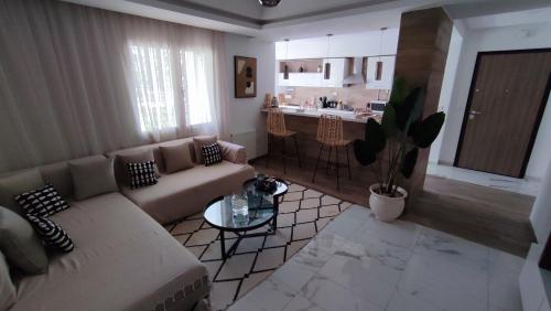a living room with a couch and a kitchen at Ideal Appart El Wahat VIP in El Aouina
