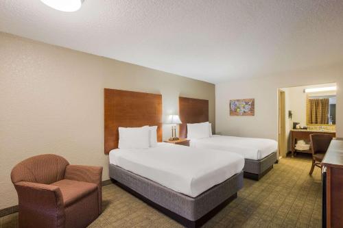 a hotel room with two beds and a chair at Econo Lodge Vidalia in Vidalia