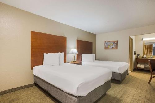 a hotel room with two beds and a desk at Econo Lodge Vidalia in Vidalia