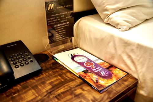 a box of food on a table next to a bed at MayFair Hotel Maitama Abuja in Abuja