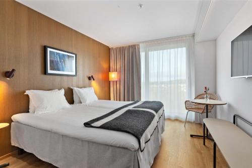 a hotel room with a large bed and a window at Ten Hotel BW Signature Collection in Upplands-Väsby