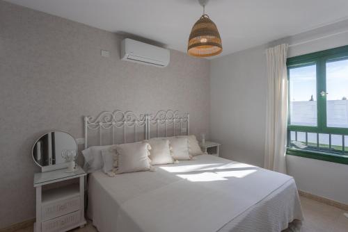 sypialnia z łóżkiem, lustrem i oknem w obiekcie Luxury Bungalow - Private Terrace - Pool - AirCon w mieście San Bartolomé