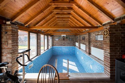 a swimming pool in a house with a wooden ceiling at River Side in Aljmaš