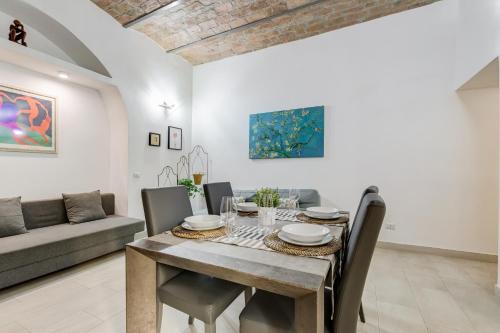 a dining room with a table and chairs and a couch at Cosy Apartment- Colosseum- Termini Railway in Rome
