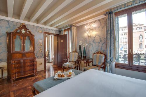 a bedroom with a table and chairs and a window at Canal Grande in Venice