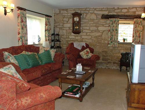 a living room with two couches and a coffee table at Cotswold Charm Stable Cottage in Chipping Campden