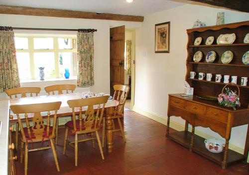 a kitchen and dining room with a table and chairs at Cotswold Charm Stable Cottage in Chipping Campden