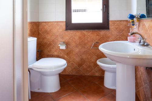 a bathroom with a toilet and a sink at Casa en la playa de Area con finca privada in Viveiro