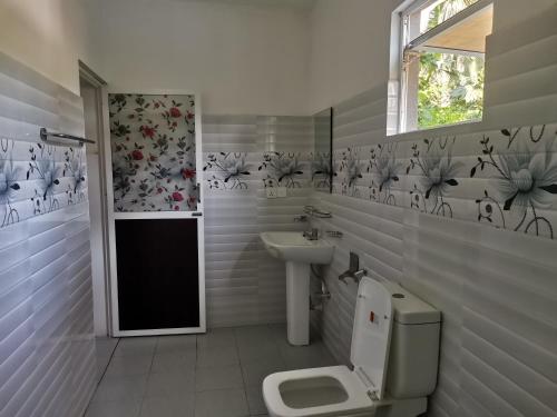łazienka z toaletą i umywalką w obiekcie Wake Up Weligama w mieście Weligama