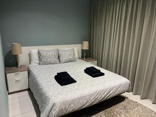 a bedroom with a bed with two black towels on it at T3 Vilamoura in Vilamoura