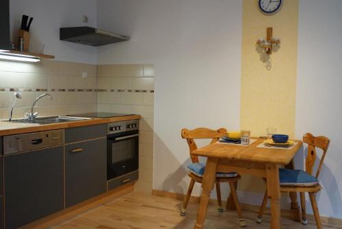 a kitchen with a wooden table with chairs and a sink at Ferienhaus Napoleon in Waldmünchen
