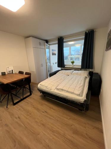 Schlafzimmer mit einem Bett, einem Tisch und einem Fenster in der Unterkunft Modernes 4er Apartment in Skilift-Nähe in Zell am See