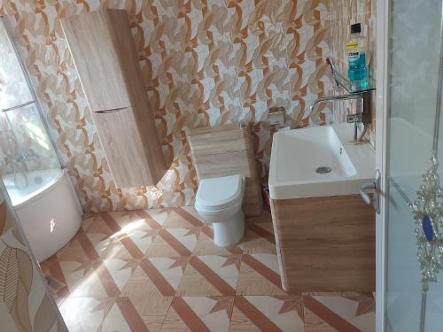 a bathroom with a toilet and a sink and a tub at Masbella Airbnb in Kumasi