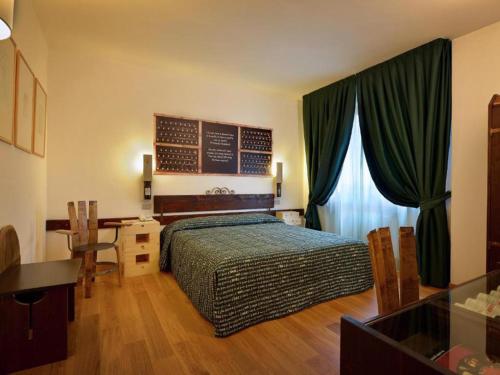 um quarto com uma cama, uma mesa e uma secretária em Hotel Giò Wine e Jazz Area em Perugia