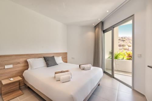 een slaapkamer met een groot bed en een groot raam bij Jardines Acoran 04 DELUXE 1B in Palm-mar