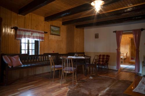 a dining room with a table and chairs and a couch at Chalúpka Rozprávkovo in Šumiac