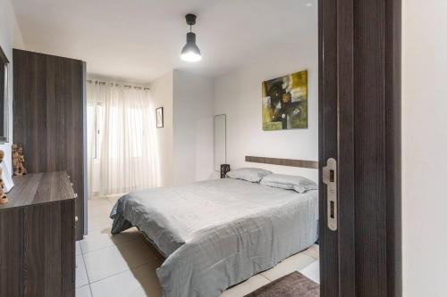 a white bedroom with a bed and a window at Beblow flats in Sliema