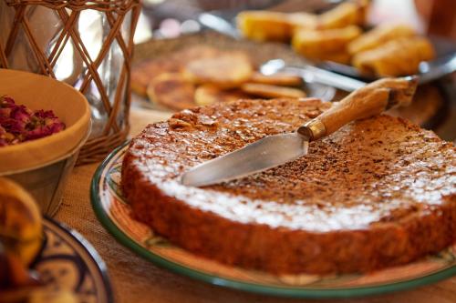 a cake on a plate with a knife on a table at Kasbah Flilou in Aït Ougliff