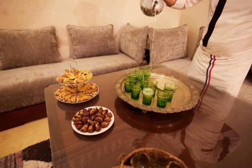 a person standing in a living room with a table with drinks at Kasbah Flilou in Aït Ougliff