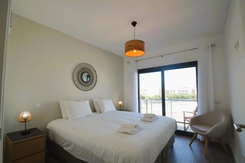 1 dormitorio con 1 cama blanca grande y ventana en Sol e mar T3, en São Martinho do Porto